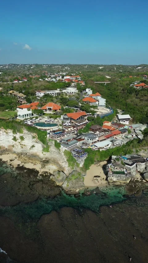 Forward flight tilting down over Uluwatu's dramatic clifftop resort complex Stock Footage 340545930