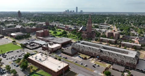 Forward flight viewing campus buildings and grounds with downtown OKC background 스톡 동영상 335673884