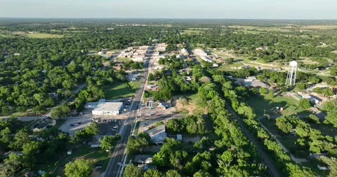 Forward flight viewing lots of trees around a small downtown area Stock Footage 335671420