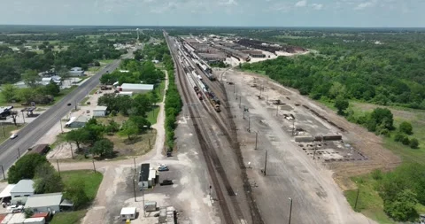 Forward flight viewing trains and stacks of railroad ties set out for drying Stock Footage 335669733