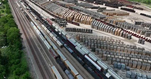Forward flight viewing trains and stacks of railroad ties set out for drying Stock Footage 335669780