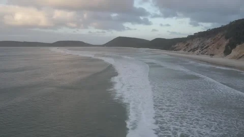 Forward high drone ocean surf point break sunset waves sandy cliffs Stock Footage 344778643
