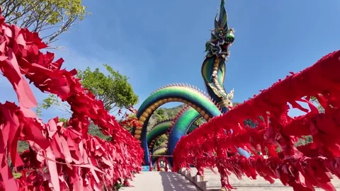 Forward motion along red ribbon pathway toward colorful naga serpent at Wat Tham Stock Footage 333118165