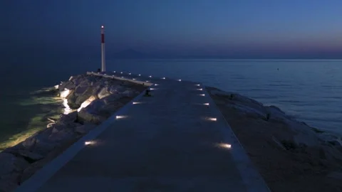 Forward Movement Along Illuminated Pier Towards Lighthouse at Blue Hour Stock Footage 341681651