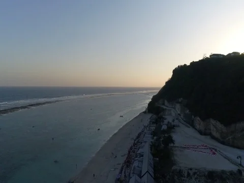 Forward over beach and ocean toward rock cliffs in Bali Indonesia. Stock Footage 80176211