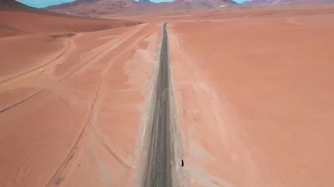 Forward reveal drone flight over a straight desert highway cutting through vast Stock Footage 334651947