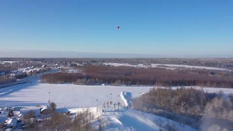 Forward rising drone view of snowy landscape and hot air balloon Vidéo 322641318