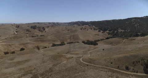 Forward shot of power line over dry grass 库存影片 117914138
