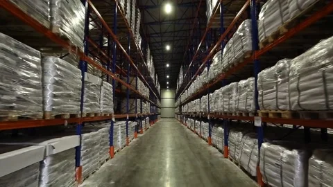 Forward shot of rows of pallets in warehouse. A path through racks of goods. Stock Footage 135053782