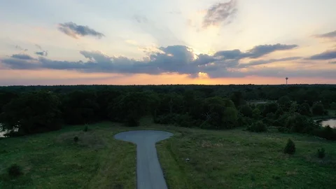 Forward slow flight over grass and trees with sunset, Grimes County Texas Stock Footage 129205009