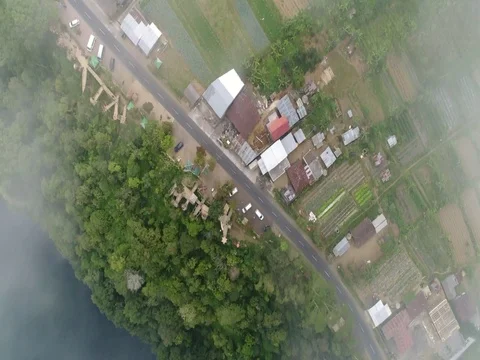 Forward through clouds, over small town, looking down in Bali Indonesia. Stock Footage 80145328