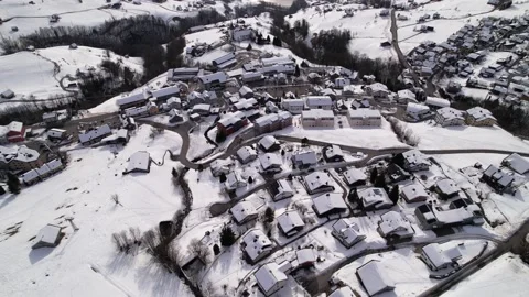 Forward tilt down over snow covered roofs in a rural swiss mountain village, Stock Footage 167469016