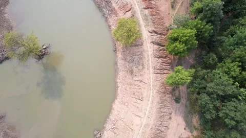 Forward Top Down Drone Reveal of Lake Shoreline with Path Trees and Natural 스톡 동영상 333642912