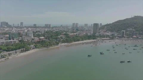 Forward tracking beach with city behind Видео 346611639