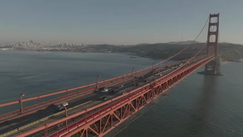 Forward tracking drone flying over San Francisco bridge with city background 库存影片 336792902