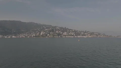 Forward tracking drone with ocean foreground, hills background Stock Footage 336792600