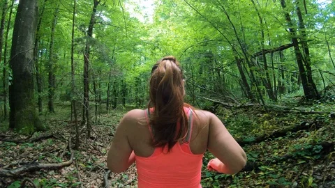 Forward tracking shot of a beautiful overweight woman with a ponytail running Stock Footage 109380624