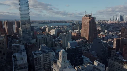 Forwards fly over buildings in city. Tilt up reveal of panorama with river and Stock Footage 166403874