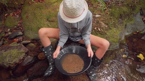 Fossicking for gold in a creek Stock-Footage 129014174