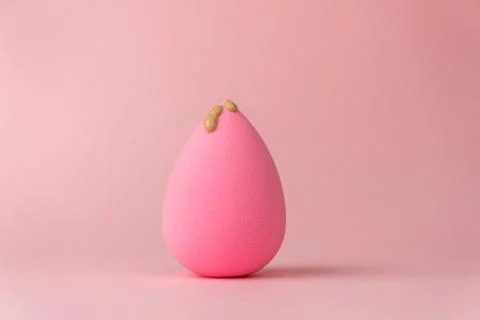 The foundation flows down the sponge for applying makeup in the form of a dro 스톡 사진