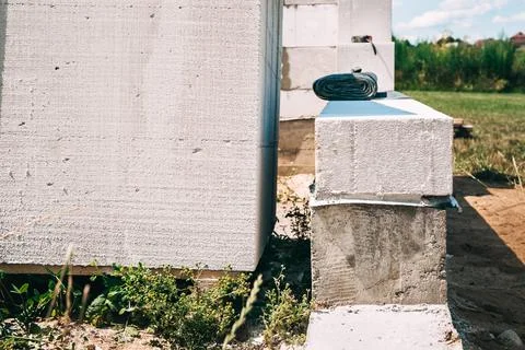 Foundation waterproofing and the first layer of gas silicate blocks close-up. Stock Photos