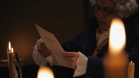 Founding Father reads document by candle light - John Adams Stock Footage 105821219