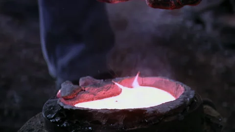 Foundry Worker Adding Flux Powder To Molten Bronze Inside Traditional Foundry 4K Stock Footage 339692903
