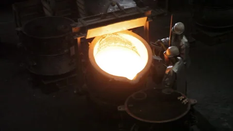 Foundry worker drop off melted metal from a ladle Stock Footage 231497100