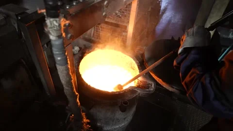 Foundry worker pouring molten iron with ladle into round casting mold closeup Stock Footage 344247667
