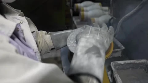 Foundry worker in protective gear polishing refractory ladle lining with Stock Footage 336681585