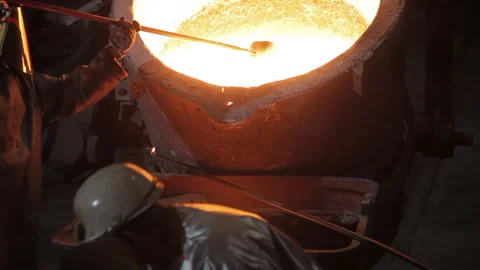 Foundry worker taking melted metal out Stock Footage 231496476