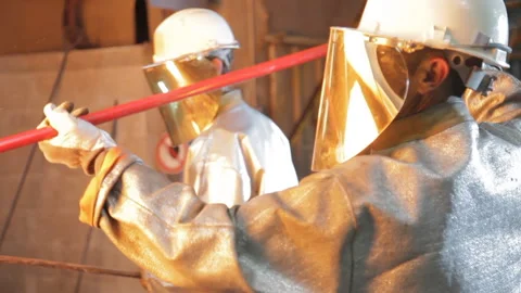 Foundry worker taking melted metal out Stock Footage 231497119