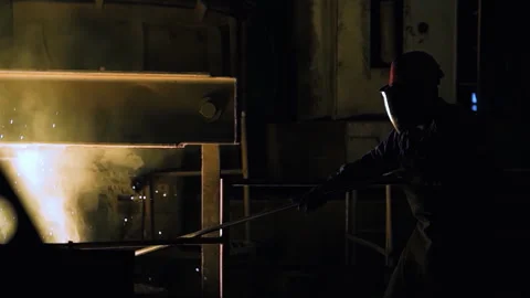 Foundry Worker Wearing Protective Gear Stirring Furnace With Rod - 4K Видео 344425986