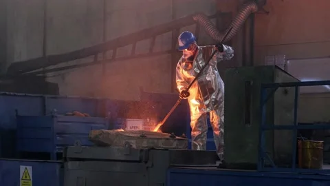 Foundry worker working with molten metal Stock Footage 197142308