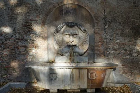 Fountain with face of river divinity in rome water Stock Photos
