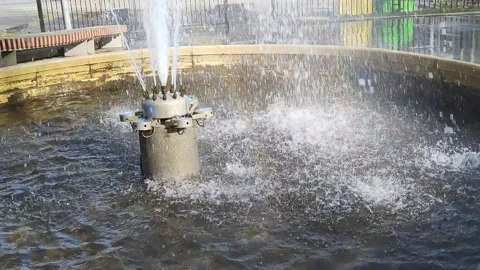 Fountain jets fall into the water creating bubbles, splashes and rainbows Stockbeeldmateriaal 188339467