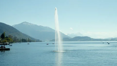 Fountain in a lake with mountains in the background Stock Footage 183303572