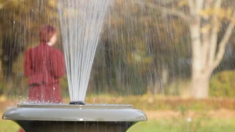 Fountain in a Large Ceramic Vase in the Park. Woman in Medieval Dress Passes By Stock Footage 267482392