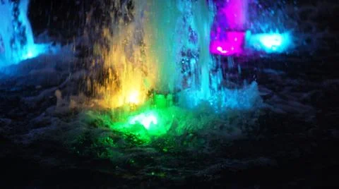 The fountain, lit by multicolored lights. Stock Photos