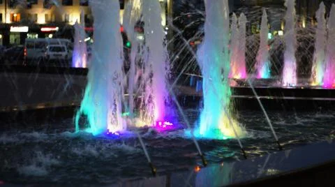 The fountain, lit by multicolored lights. Stock Photos