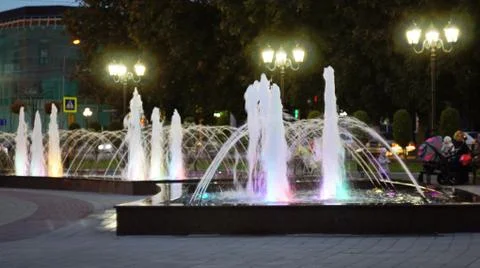 The fountain, lit by multicolored lights. Stock Photos