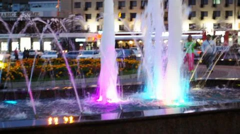 The fountain, lit by multicolored lights. Stock Photos