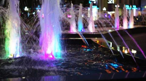 The fountain, lit by multicolored lights. Stock Photos