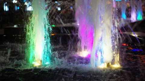 The fountain, lit by multicolored lights. Stock Photos