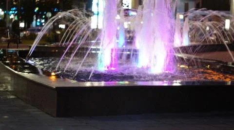 The fountain, lit by multicolored lights. Stock Photos