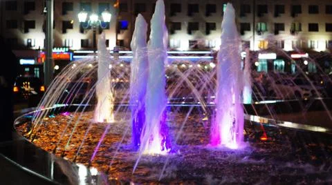 The fountain, lit by multicolored lights. Stock Photos