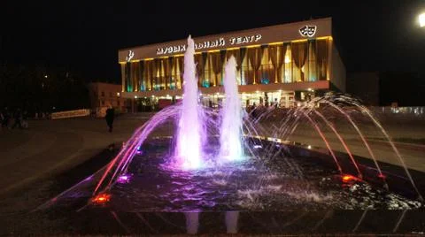 The fountain, lit by multicolored lights. Stock Photos