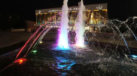 The fountain, lit by multicolored lights. Stock Photos
