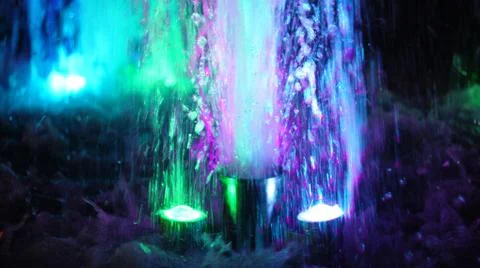 The fountain, lit by multicolored lights. Stock Photos