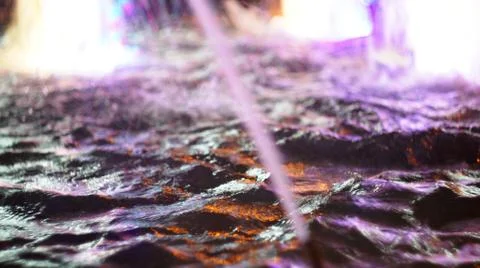 The fountain, lit by multicolored lights. Stock Photos